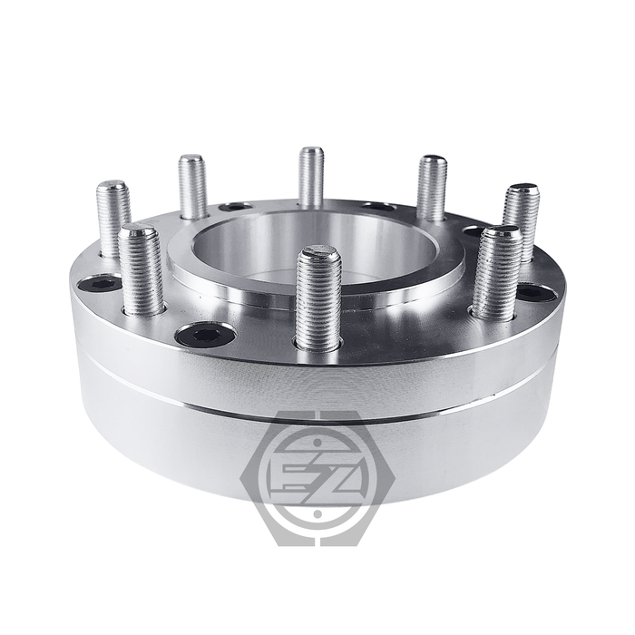 Close-up of a CNC machined silver metal Hub Centric Wheel Adapter 5x5.5 To 8x170 with multiple threaded bolts in a circular pattern. The sturdy 2 thick adapter, designed for automotive use, features a logo with stylized letters at the bottom of the image.