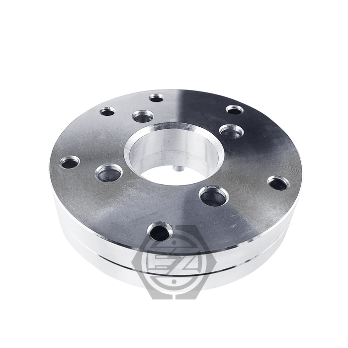 The Hub Centric Wheel Adapter 4x100 To 5x120, with a 1.5 thickness, features a smooth, reflective metal flange with symmetrically arranged circular holes and a base logo, making it perfect for BMW wheels.