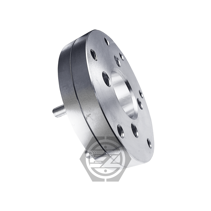 Close-up of a Hub Centric Wheel Adapter 4x100 to 5x120, featuring a metallic finish with multiple bolt holes and a geometric logo. Ideal for BMW wheels, it enhances hub centric design integration. Reflective machined finish and central opening combine aesthetics and function.