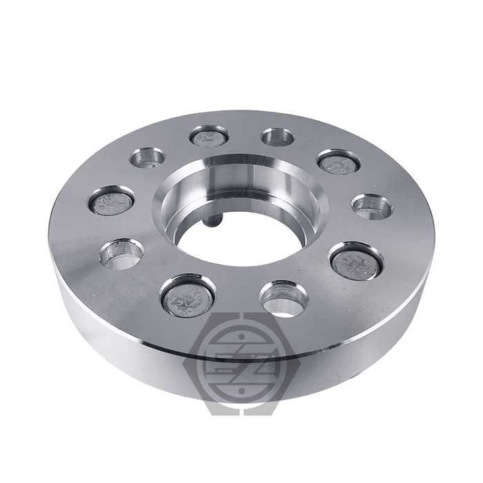 A Hub Centric Wheel Adapter 5x130 Porsche pair, crafted from billet aluminum with multiple holes and a shiny silver finish, features circular cutouts around a central hole on a white background. A subtle watermark logo appears at the bottom center like Porsche hub centric adapters.