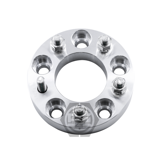 The Wheel Adapter 5x115 To 5x115 (Pair) is a CNC machined 6061 T6 billet aluminum metallic spacer with five studs in a circular pattern and polished with small recesses, supporting 5 lug 115mm patterns. A subtle logo is beneath it.
