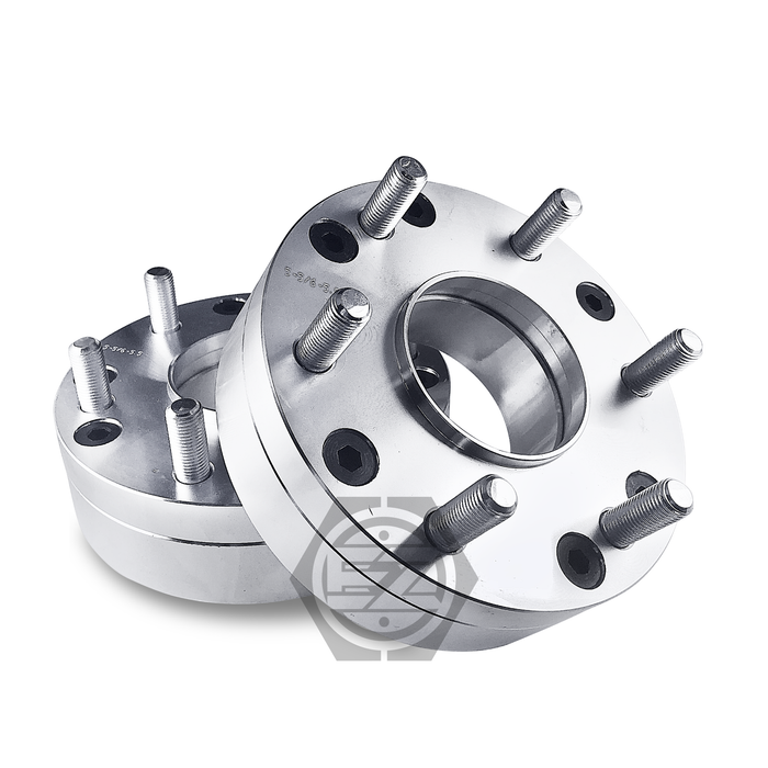 Two hub centric wheel adapters, expertly crafted from billet aluminum with multiple bolts and circular holes, are stacked on a white background. The top one is angled left, showcasing thickness and design details. Product: Hub Centric Wheel Adapter 5x4.5 To 6x5.5 Thickness 2 (Pair).